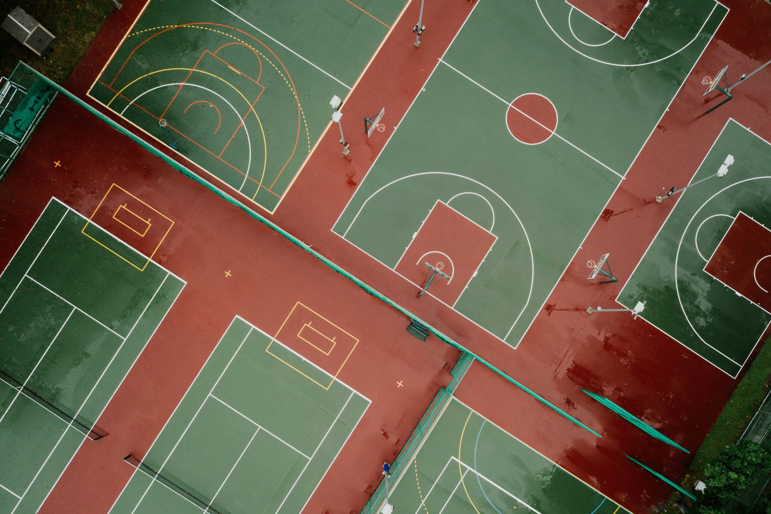 Aerial view of multi-use school sports courts showing pitch and court line markings