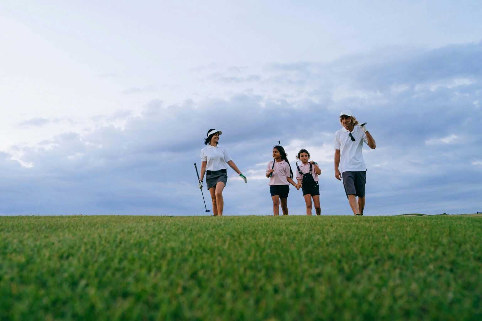 Junior golfers from a youth sport programme walking across a course